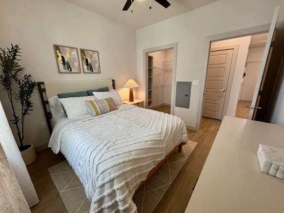 A bedroom with a large bed and a ceiling fan.