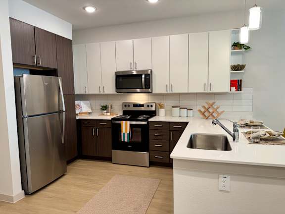 A modern kitchen with a stainless steel refrigerator and a white countertop.