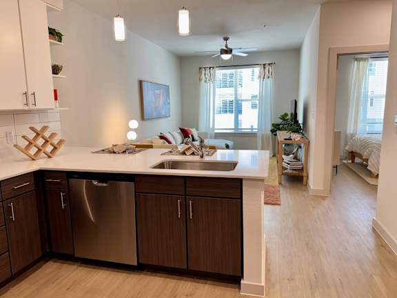 A kitchen with a stainless steel dishwasher and a white countertop.