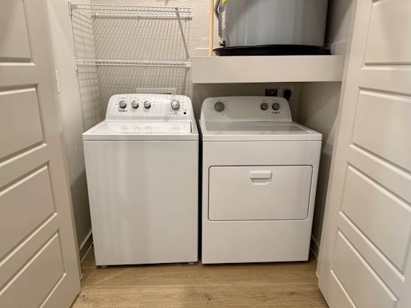 Two white front loading washing machines in a laundry room.