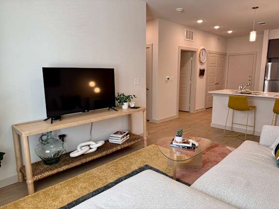 A living room with a flat screen TV on a wooden stand.