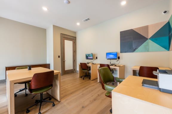 a room with two computers and three chairs