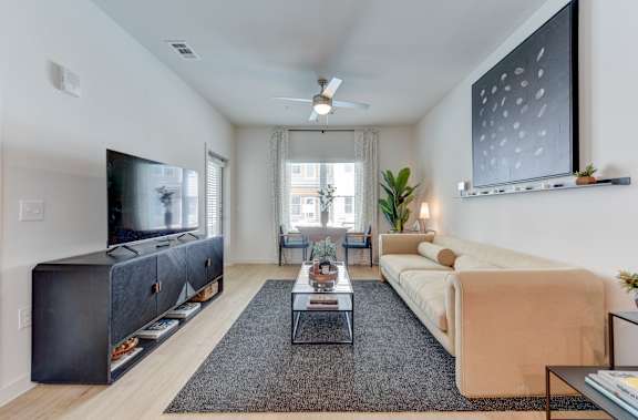 Furnished living room with modern sofa and entertainment center at Matador Apartments, Austin, 78745
