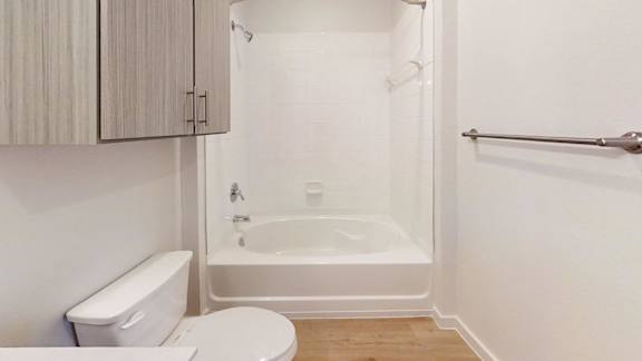 A white bathroom with a toilet, sink, and bathtub.