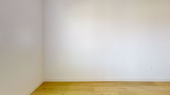 A room with a wooden floor and white walls.