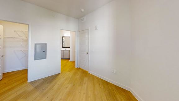 A room with a wooden floor and white walls. at Park South Apartments, Texas, 78748