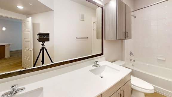 A bathroom with a sink, toilet, and a mirror at Park South Apartments, Texas, 78748