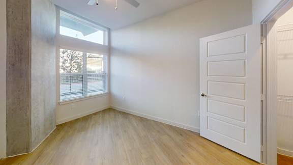 A room with a white door and a window with blinds. at Park South Apartments, Texas