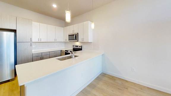A kitchen with white cabinets and a stainless steel refrigerator. at Park South Apartments, Austin, Texas