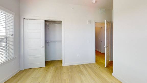 A white door is open to a room with wooden floors.