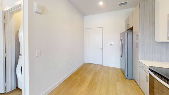 A kitchen with a refrigerator and a washing machine.