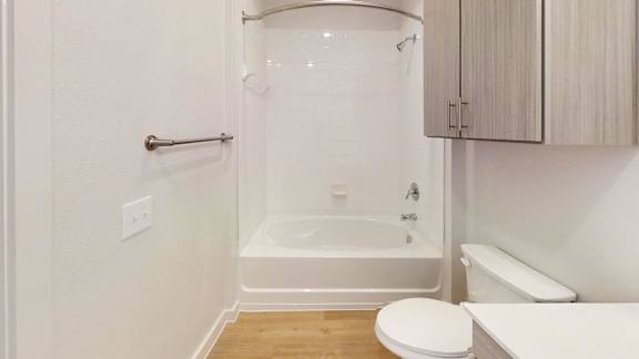 A white bathroom with a toilet, sink, and bathtub.