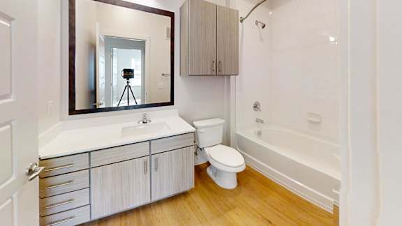 A bathroom with a white sink, toilet, and bathtub.