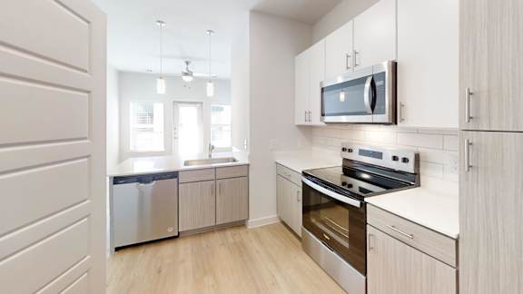 A modern kitchen with a stainless steel refrigerator, oven, and microwave.