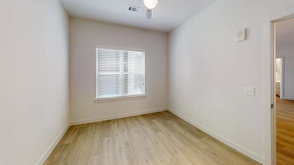 A room with a window and wooden flooring. at Park South Apartments, Austin, 78748