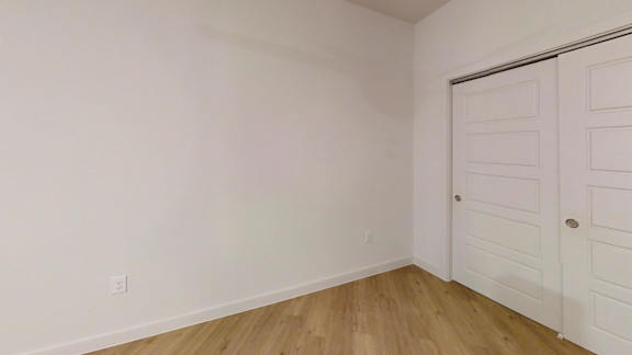 A room with a white door and wooden floor. at Park South Apartments, Texas, 78748