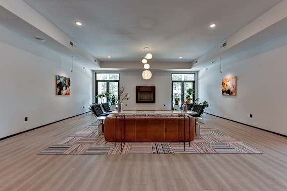 A modern living room with a wooden coffee table and striped rug.