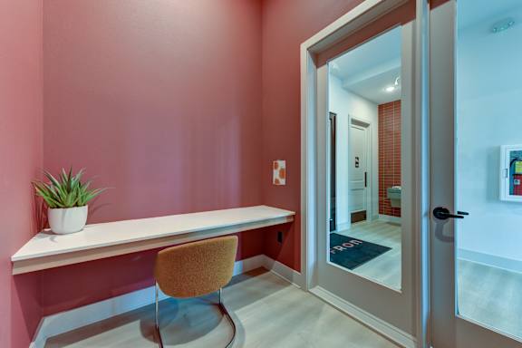 A room with a white desk and a brown chair.