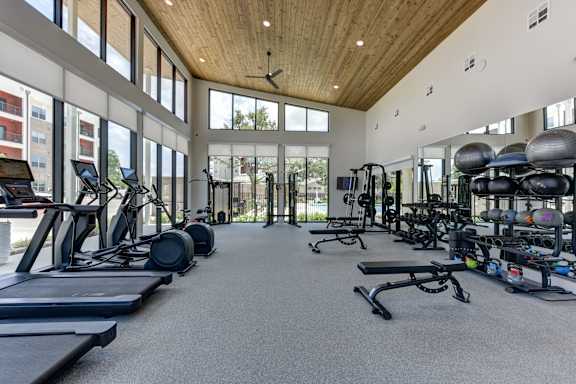 A spacious gym with treadmills, exercise bikes, and weightlifting equipment.