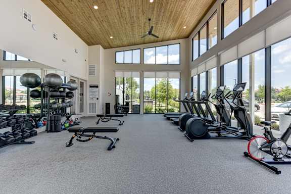 A spacious gym with a variety of equipment including treadmills, elliptical machines, and weights.