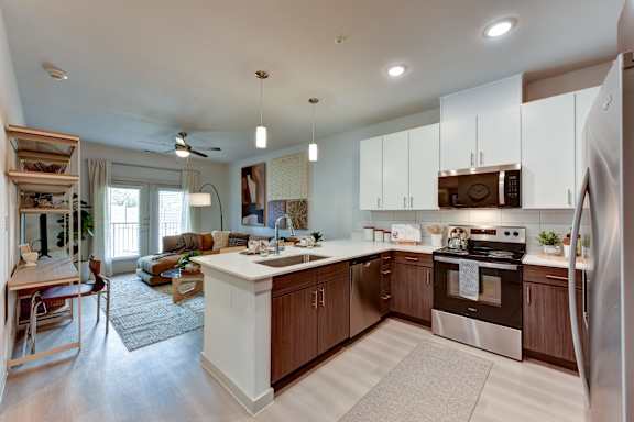 Open concept kitchen and living area with white island at Bridge at Saffron Apartments, Texas, 78717