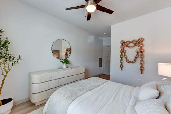 Bedroom with textured dresser and chain wall art at Bridge at Saffron Apartments, Austin, 78717