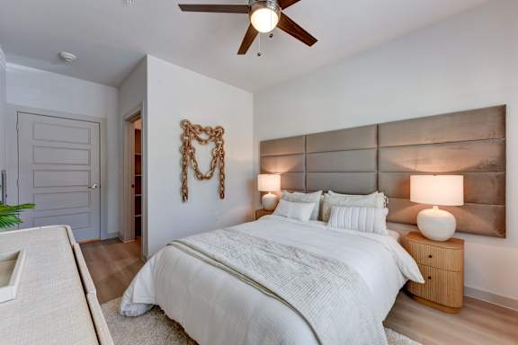 Bedroom with upholstered headboard and wood nightstands at Bridge at Saffron Apartments, Austin