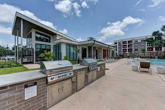 A modern building with a grill area in front.
