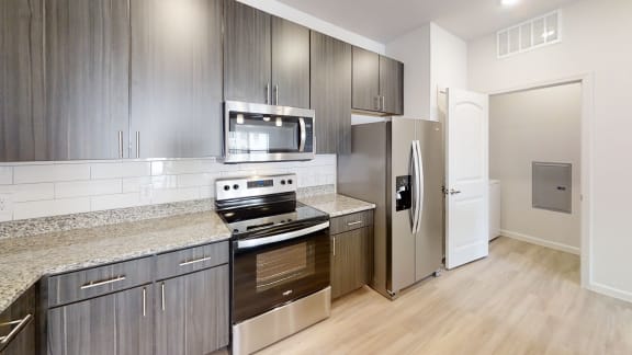 a kitchen with dark wood cabinets and stainless steel appliances at Avery Ranch, Austin Texas