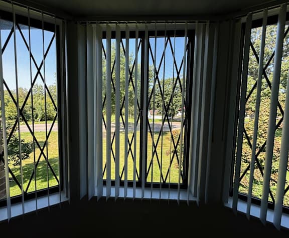 Bay window with vertical blinds and decorative grilles at Charter Oaks Apartments, Davison