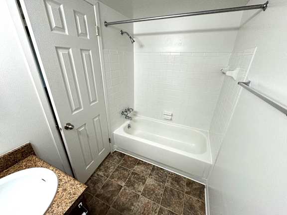 Bathroom with white subway tile and alcove tub at Charter Oaks Apartments, Davison, MI, 48423