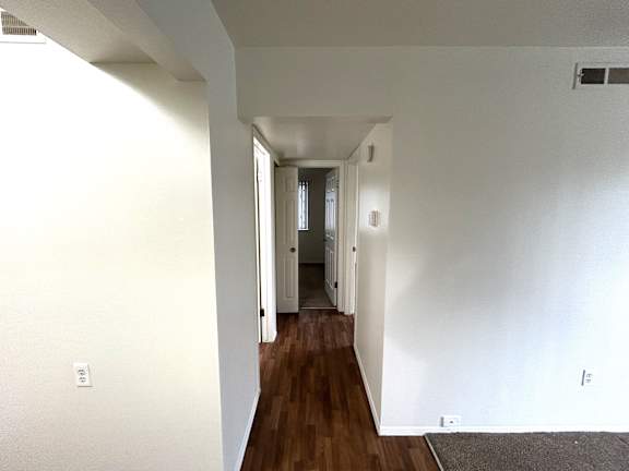 A long hallway with vinyl plank flooring.
