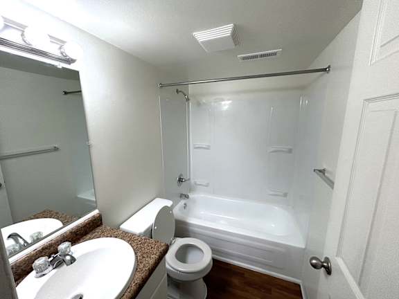 A white bathroom with a toilet, sink, and bathtub.