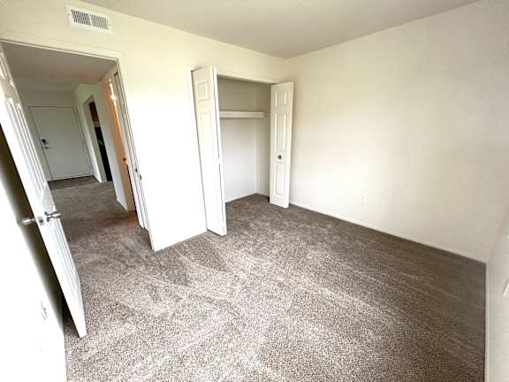 A bedroom with carpeted floor and white walls.