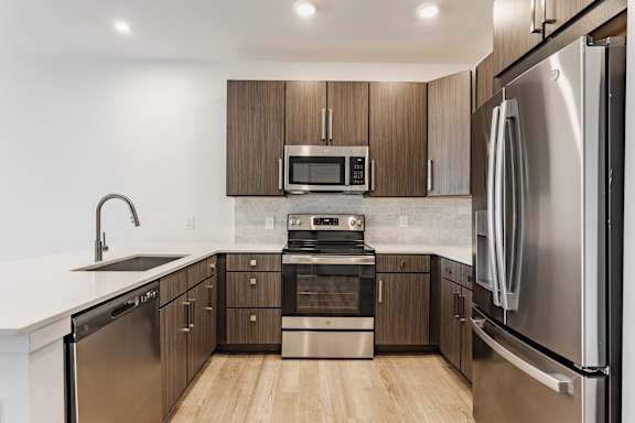 A modern kitchen with stainless steel appliances and wooden cabinets