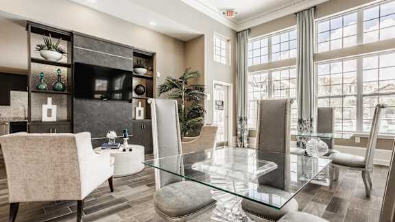 A modern living room with a glass table and chairs.
