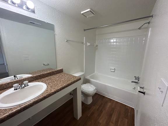 A bathroom with a sink, toilet and bathtub.