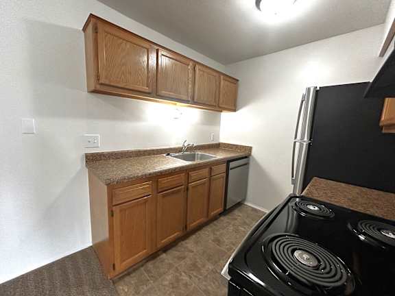 Kitchen with granite counters and stainless steel appliances at Charter Oaks Apartments, Michigan, 48423