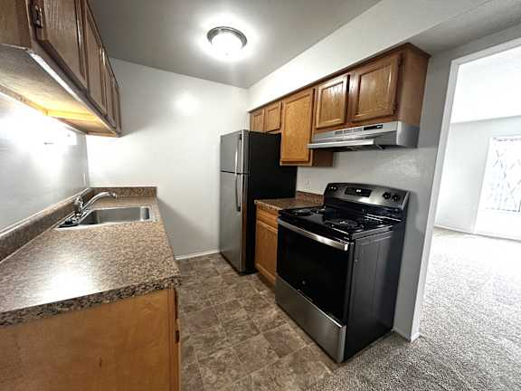 Kitchen with black appliances and brown countertops at Charter Oaks Apartments, Michigan