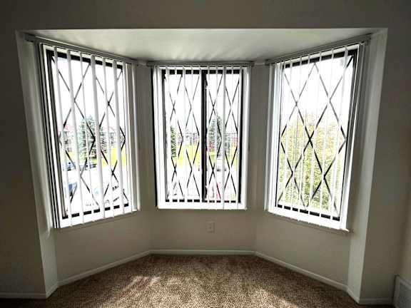 Bay window alcove with decorative grilles and carpet at Charter Oaks Apartments, Michigan, 48423