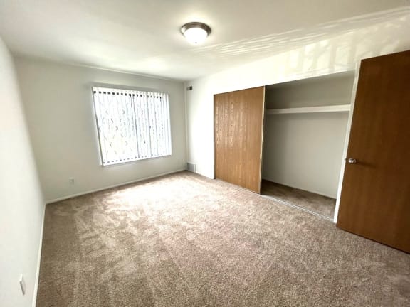 Empty bedroom with open closet and carpet flooring at Charter Oaks Apartments, Davison, MI, 48423