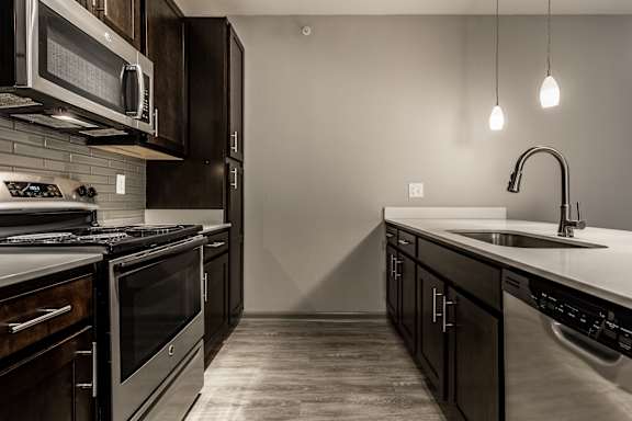 an empty kitchen with stainless steel appliances and a sink at Bella Vista Apartments, Indiana, 46038