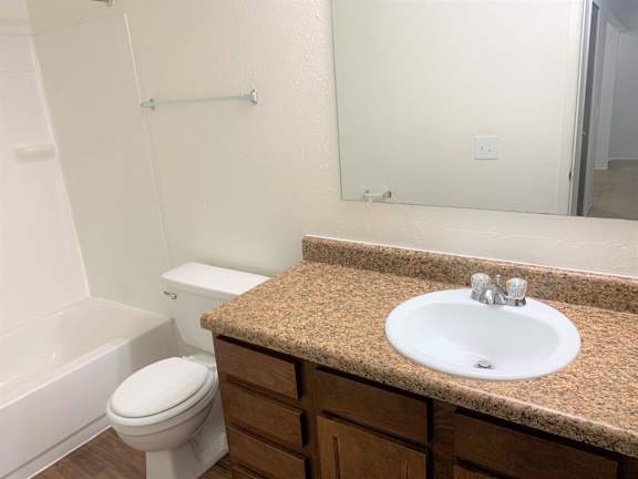 A bathroom with a sink, toilet, and bathtub.