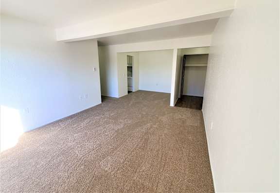 A living room and dining room with carpeted floor and white walls.