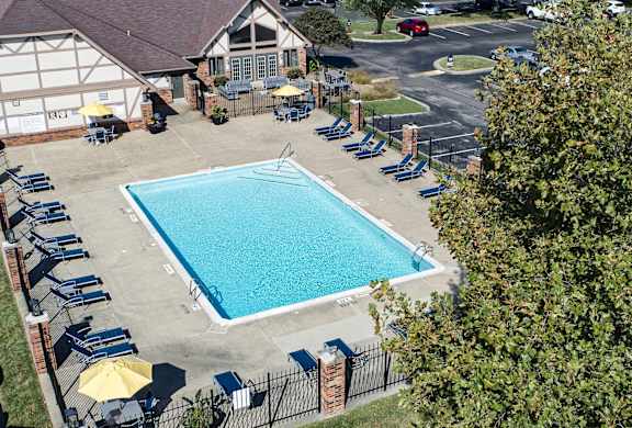 a swimming pool in front of a house with chairs around it at The Timbers Apartments, Indiana, 47715