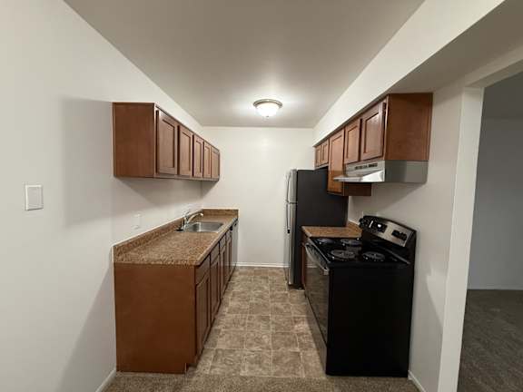 a kitchen with a stove refrigerator and sink and