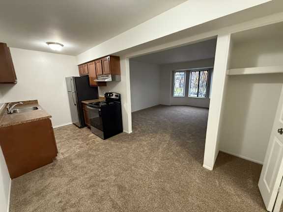 kitchen and living room with a refrigerator and a sink