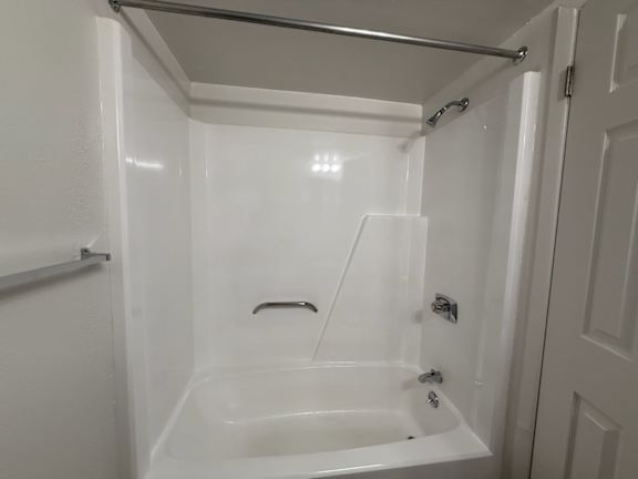 a white bathroom with a tub and a shower
