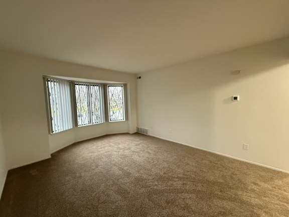 the living room of an empty house with a large window