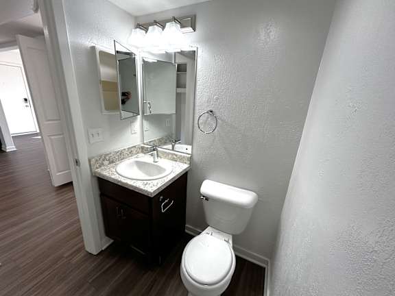 Bathroom with dark vanity and granite countertop at Charter Oaks Apartments, Davison